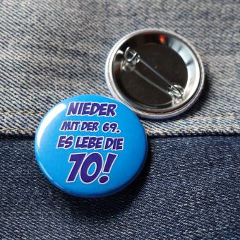 Ansteckbutton Nieder mit der 69 - es lebe die 70 auf Jeans mit Rückseite