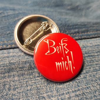 Ansteckbutton Beiß mich! auf Jeans mit Rückseite