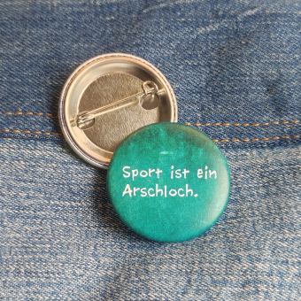 Ansteckbutton Sport ist ein Arschloch auf Jeans mit Rückseite