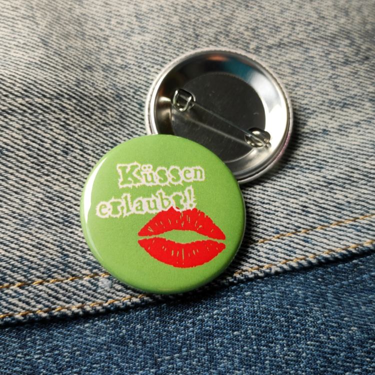 Ansteckbutton Küssen erlaubt auf Jeans mit Rückseite