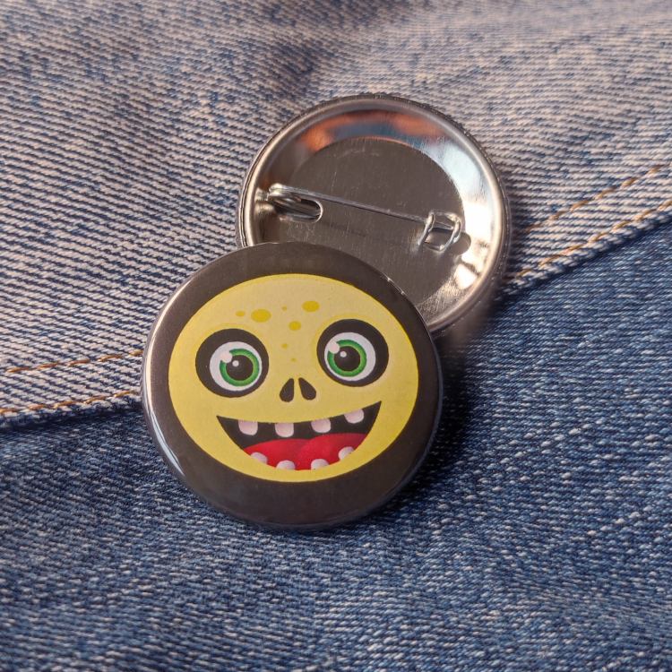 Ansteckbutton Fratze gelb auf Jeans mit Rückseite
