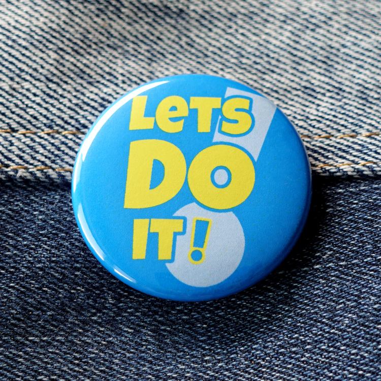 Ansteckbutton Lets do it! auf Jeans
