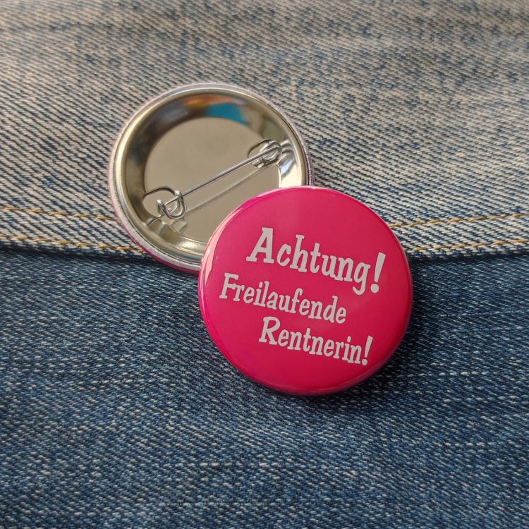 Ansteckbutton Achtung! Freilaufende Rentnerin auf Jeans mit Rückseite