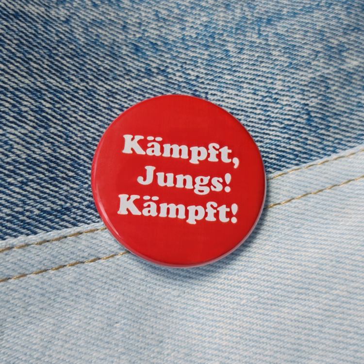 Ansteckbutton Kämpft, Jungs! Kämpft auf Jeans